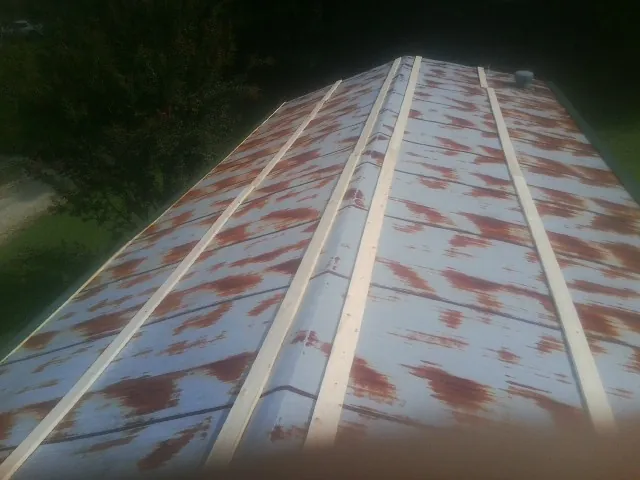 Rusted metal roof panels with new wood purlins before replacement — Storm Damage Roof Repair in Lombard by Roofing Brothers