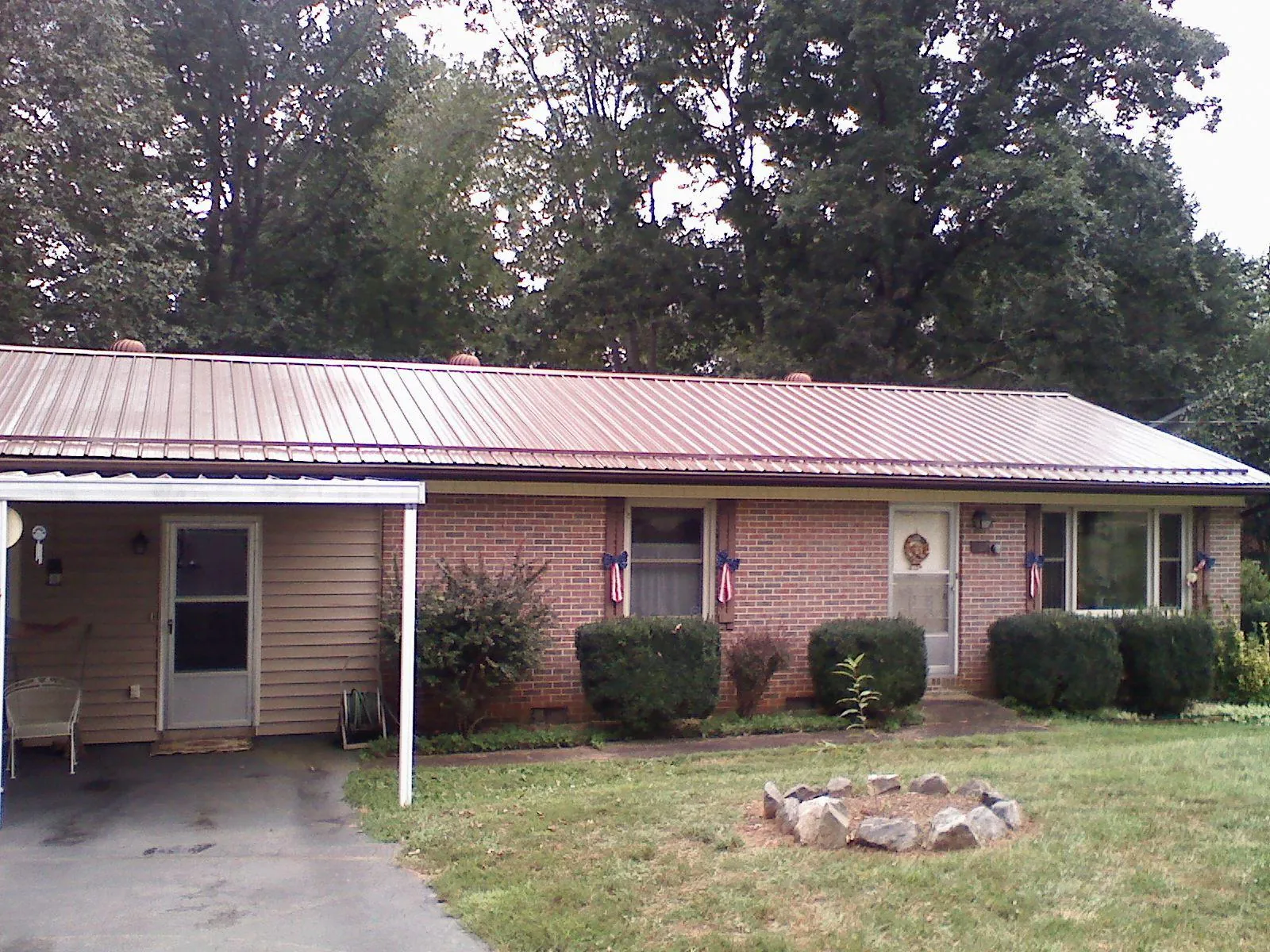 Bronze metal roof and carport on a brick ranch home — Roof Repair work by our crew in Lombard