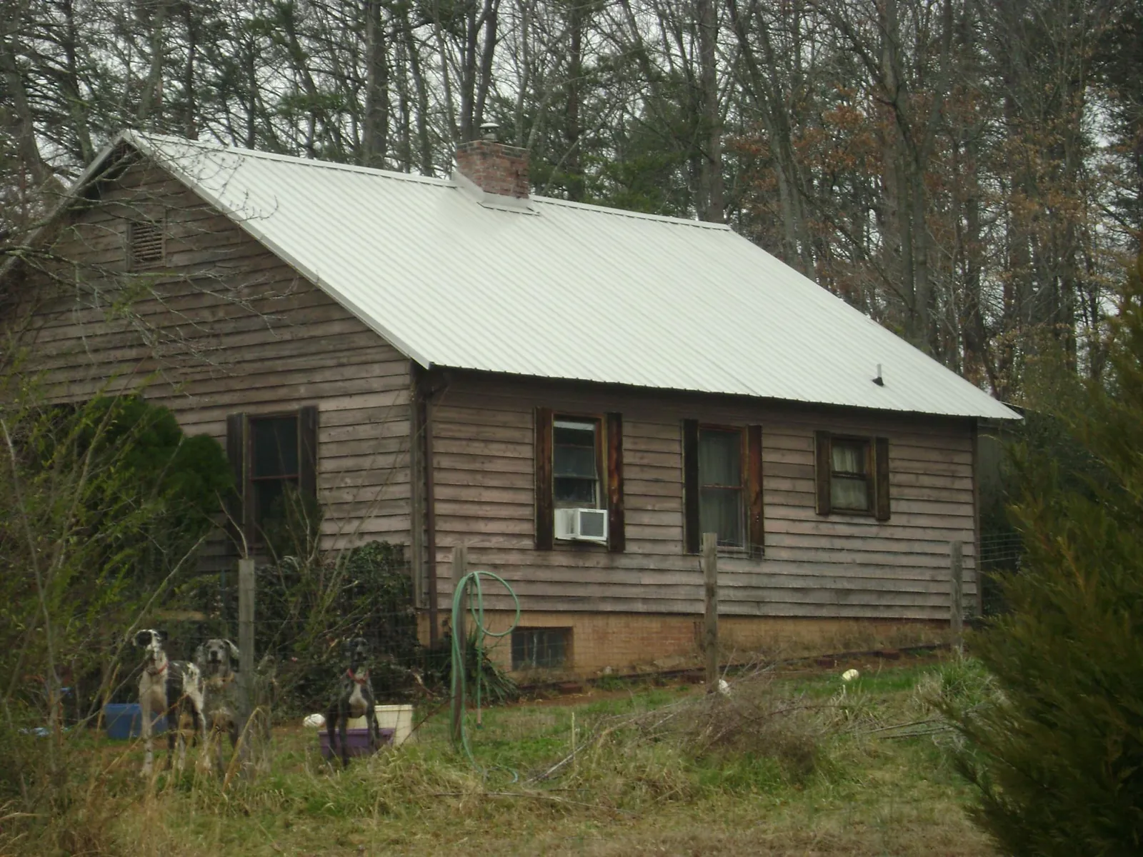 White metal roof on an old wood sided farmhouse, from a Metal Roof Installation job in Lombard